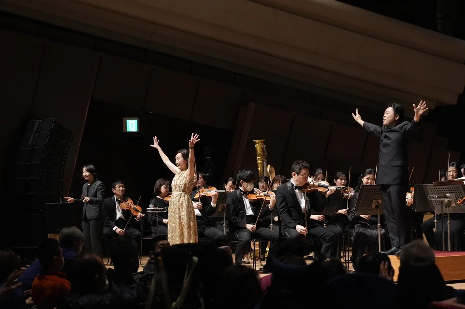 指揮者と女性歌手がパフォーマンスを行うオーケストラ