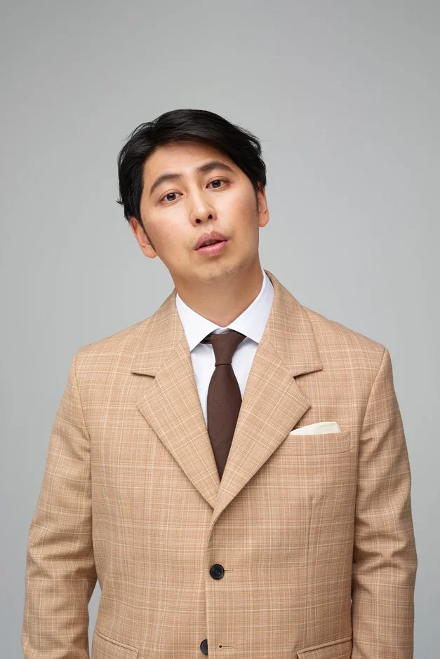 ベージュのチェック柄スーツを着た男性のポートレート