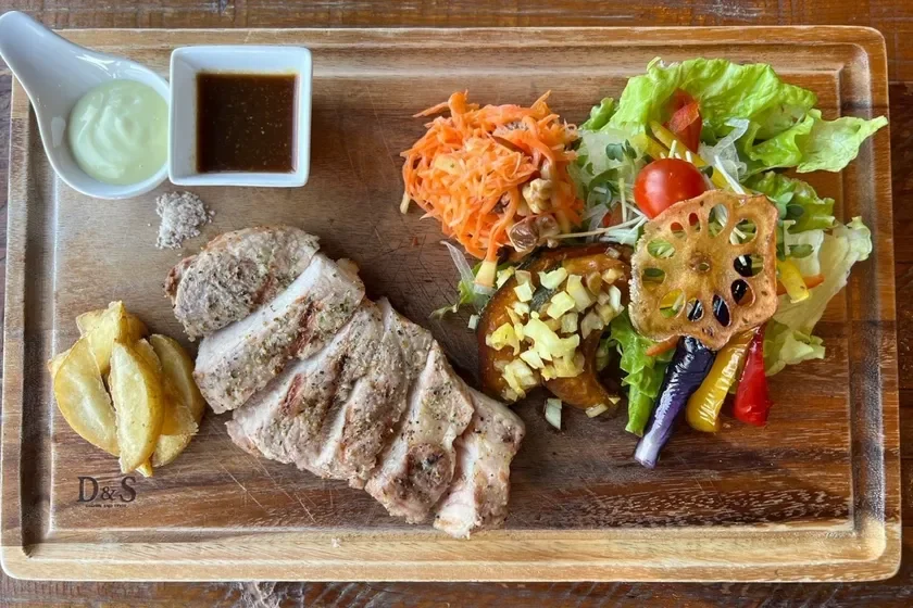 グリルされた肉と色とりどりの野菜、ポテト、サラダが添えられたヘルシーなプレートランチ